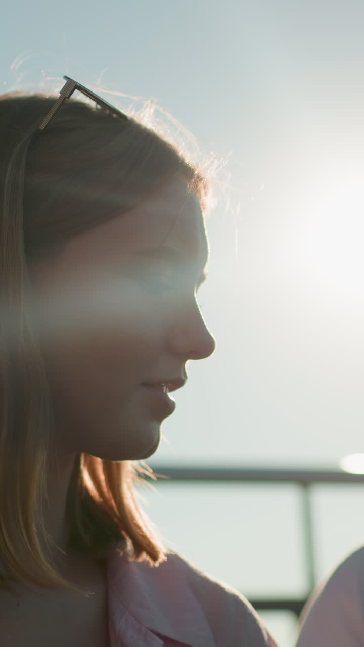 머리에 안경을 쓴 여자의 빛 실루이 야외에서 동료와 이야기하고, 머리를 둘러싼 부드러운 빛, 배경에 철 레일링