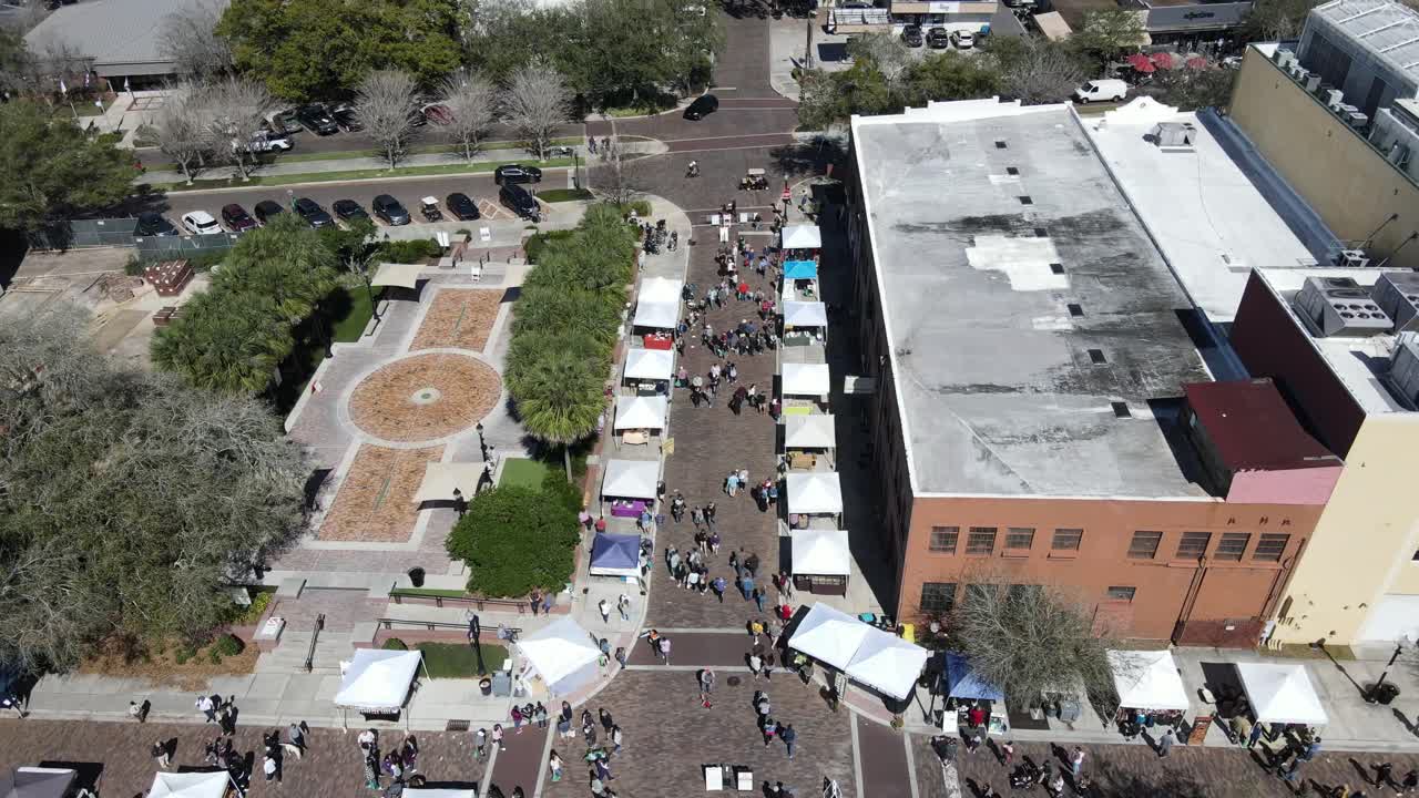 Drone flying over people in small town at farmers market