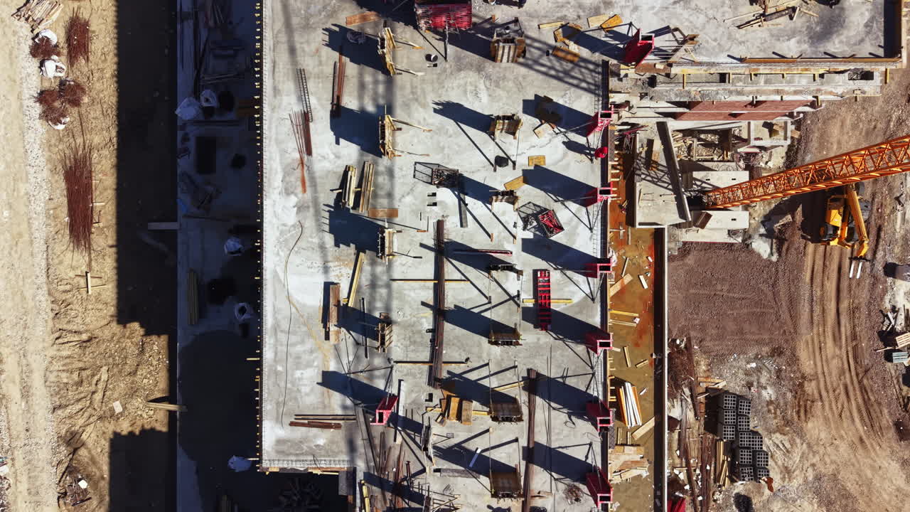 Construction site in progress with workers and machinery on a building project in a developing area during daytime hours