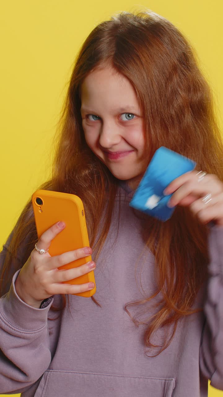 niña usa tarjeta de crédito, teléfono inteligente mientras transfiere dinero, gasta compras en línea.