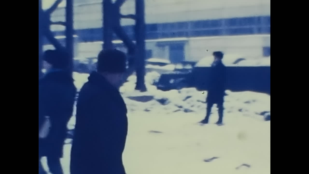 Group Walking Down Snow Covered Street at Soviet Factory. CIRCA USSR 1970: Group Walking Down Snow Covered Street at Soviet Factory