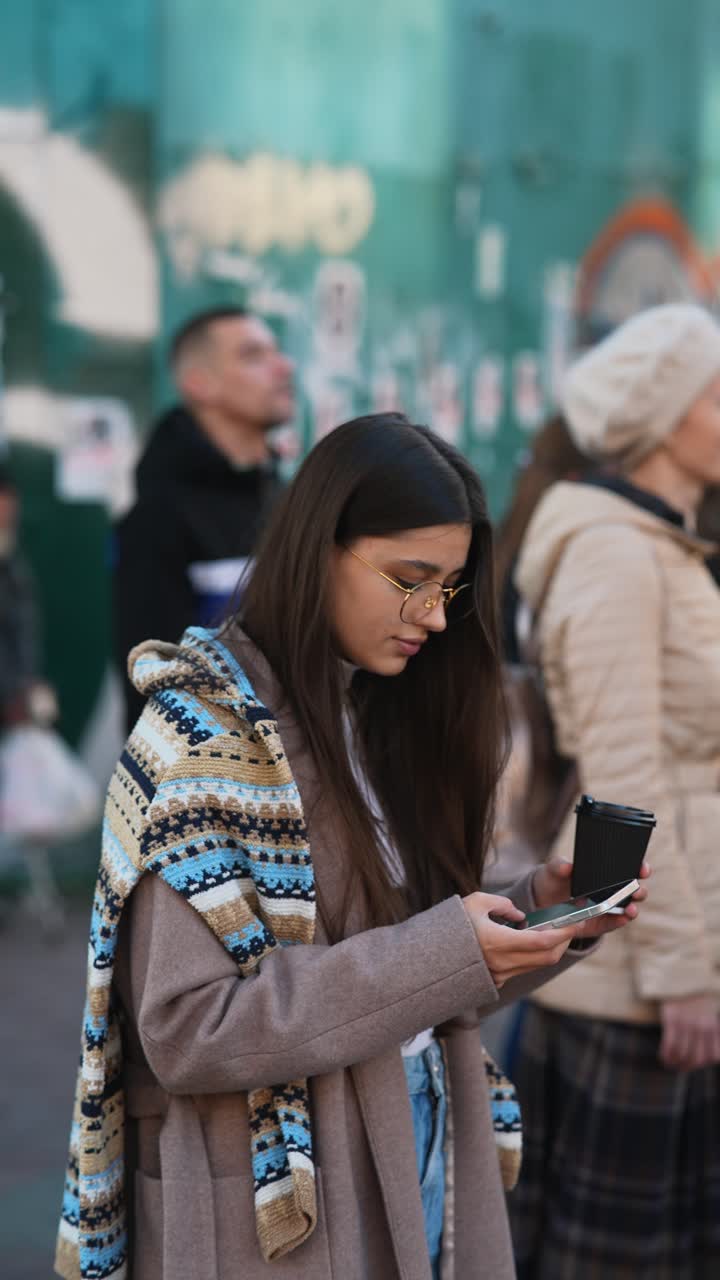 mujer usando el teléfono en una multitud
