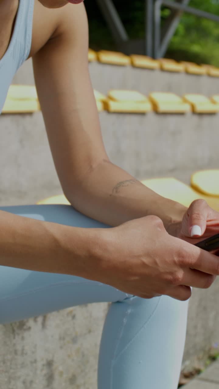 mujer usando teléfono inteligente en el estadio