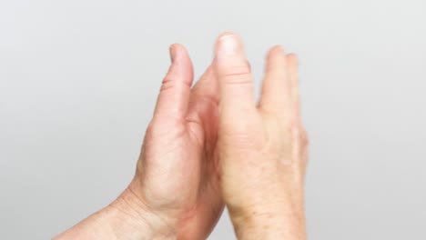 a view of hands claping from the back of the wrists is isolated on a white background