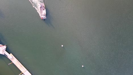 aerial top down of salvage tug, towing submerged sailboat and dragging it towards the shore