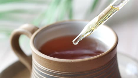 poniendo aceites esenciales de eucalipto en una taza de té