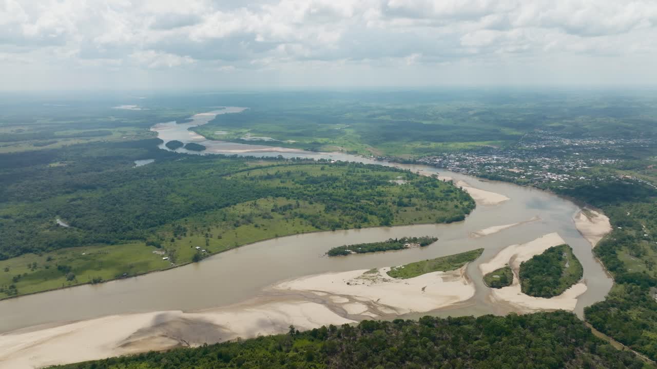 el río sinuoso de florencia, colombia y el paisaje exuberante bajo un cielo nublado, vista aérea