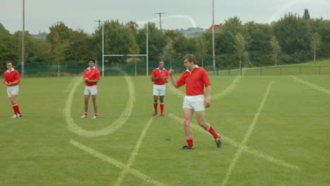 group of multi ethnic rugby players playing football on football field.