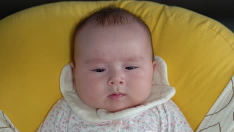 Crying-Angry-disturbed-Baby-Lying-On-The-Soft-yellow-Cushion-Inside-The-House-a-face-close-up-shot