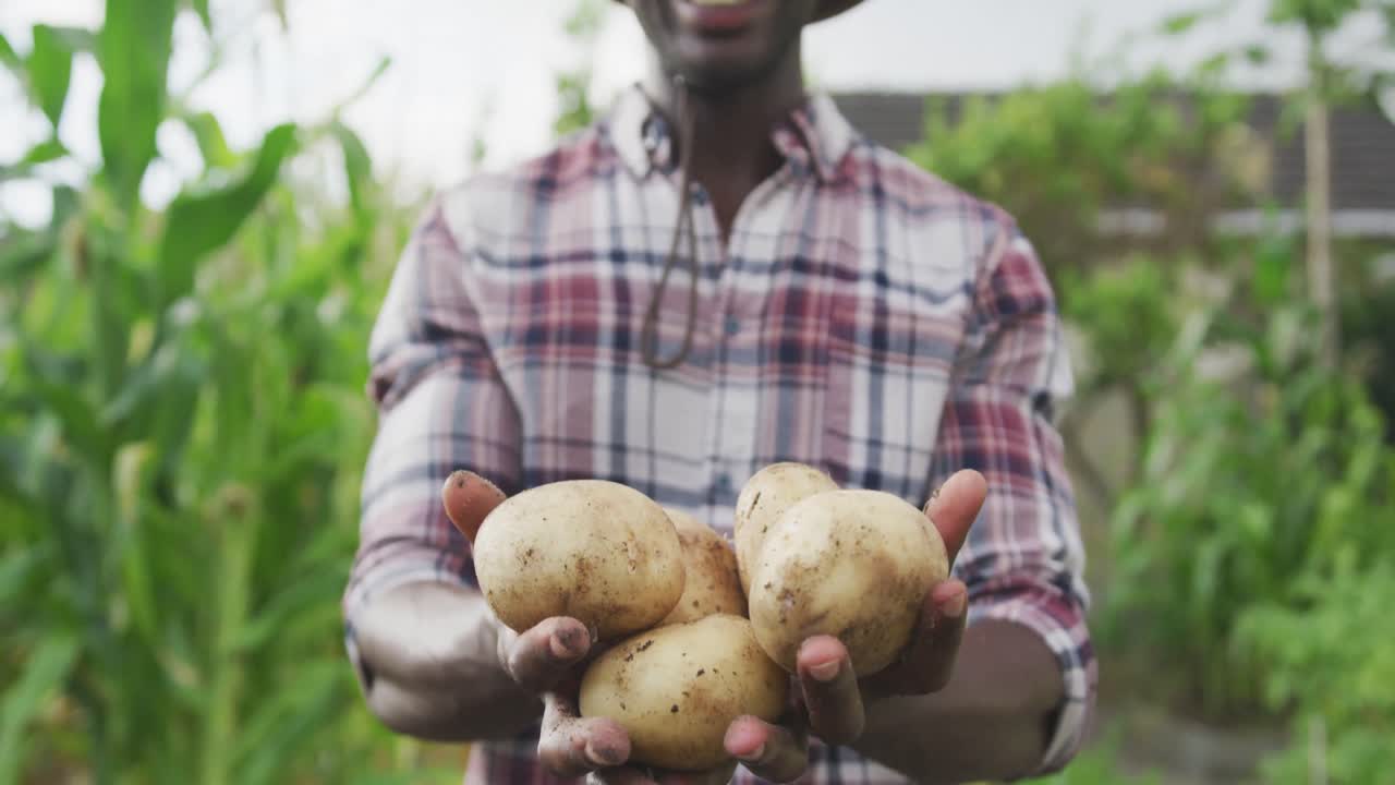hombre afroamericano mostrando patatas en la cámara