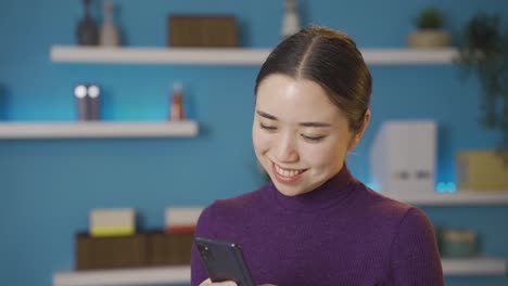 행복한 아시아 여성이 휴대폰으로 누군가와 얘기하고 있습니다.