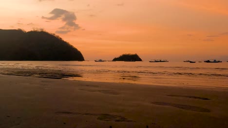 Hermosa-Puesta-De-Sol-Sobre-Una-Playa-De-Arena-Y-Pequeñas-Olas-Del-Océano-Costa-Rica-Hora-Dorada-Paraíso-Tropical