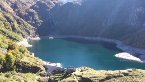 Lago-Artificial-Lac-D&#39;oô-En-Los-Pirineos-Franceses-Con-Cascada-Y-Muro-De-Presa,-Disparo-De-Revelación-De-Descenso-Aéreo