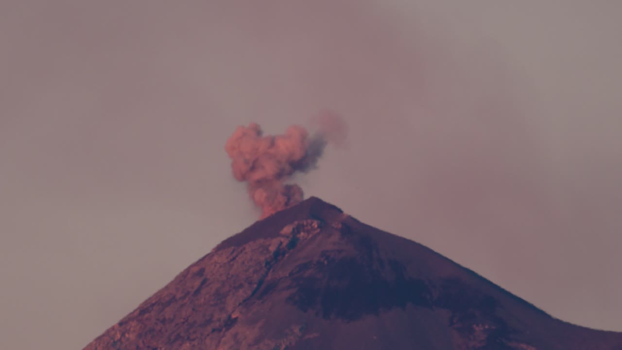 A view of Volcan de Fuego erupting at sunrise. Lava is visible