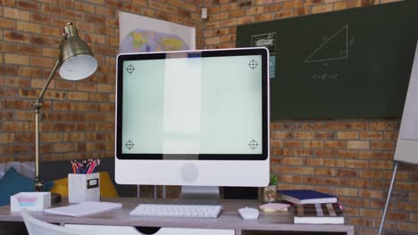 vista de la computadora y otros suministros escolares en la mesa en el aula de la escuela