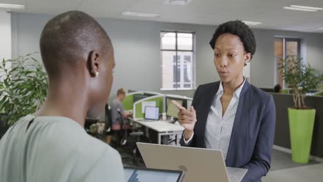 Zwei-Afroamerikanische-Geschäftsfrauen-Diskutieren-über-Arbeit-Und-Nutzen-Laptop-Und-Tablet-Im-Büro-In-Zeitlupe