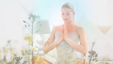 Animation-Von-Blumen-über-Einer-Kaukasischen-Frau,-Die-Yoga-Praktiziert-Und-Meditiert