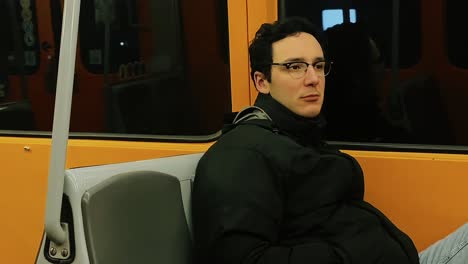 lonely man sitting in a subway train in vienna, austria, looking out