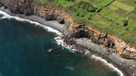 waves crashing on the rocky coastline feteira hamlet in terceira island, portugal
