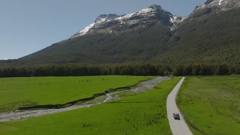 car on gravel road from glenorchy to paradise in scenic valley, new zealand