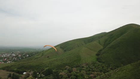 paragliding in the mountains. green fields, hills