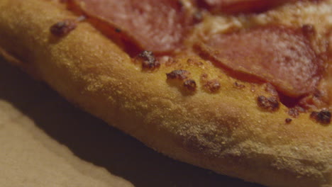 extreme close up of crust of pepperoni pizza