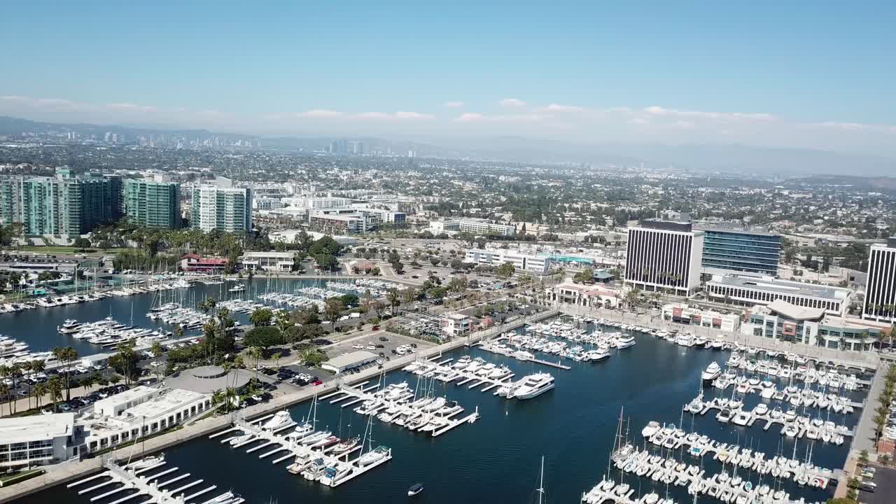 Aerial panoramic shot of marina del Rey port in California during sunny day. Parking yachts in large area. Los Angeles and Santa Monica in near. Wide shot