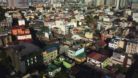 drone disparado sobre viviendas vibrantes, hora dorada en la ciudad de makati, manila, filipinas