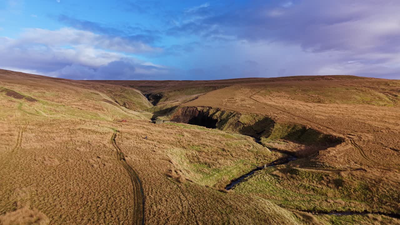 Hawes, Yorkshire Dales yakınlarındaki altın rengi fundalıklar ve vadiler, masmavi gökyüzü altında.