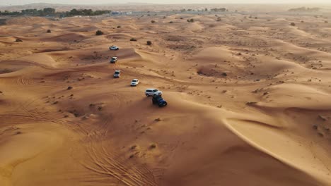 aerial view of 4x4 vehicles driving through sand dunes