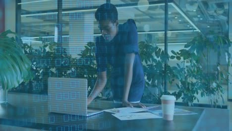 Animation-Von-Binärcodes-über-Einer-Afroamerikanerin,-Die-Berichte-Auf-Einem-Laptop-Im-Büro-Analysiert