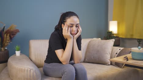 depressed young woman covering her face with her hand.