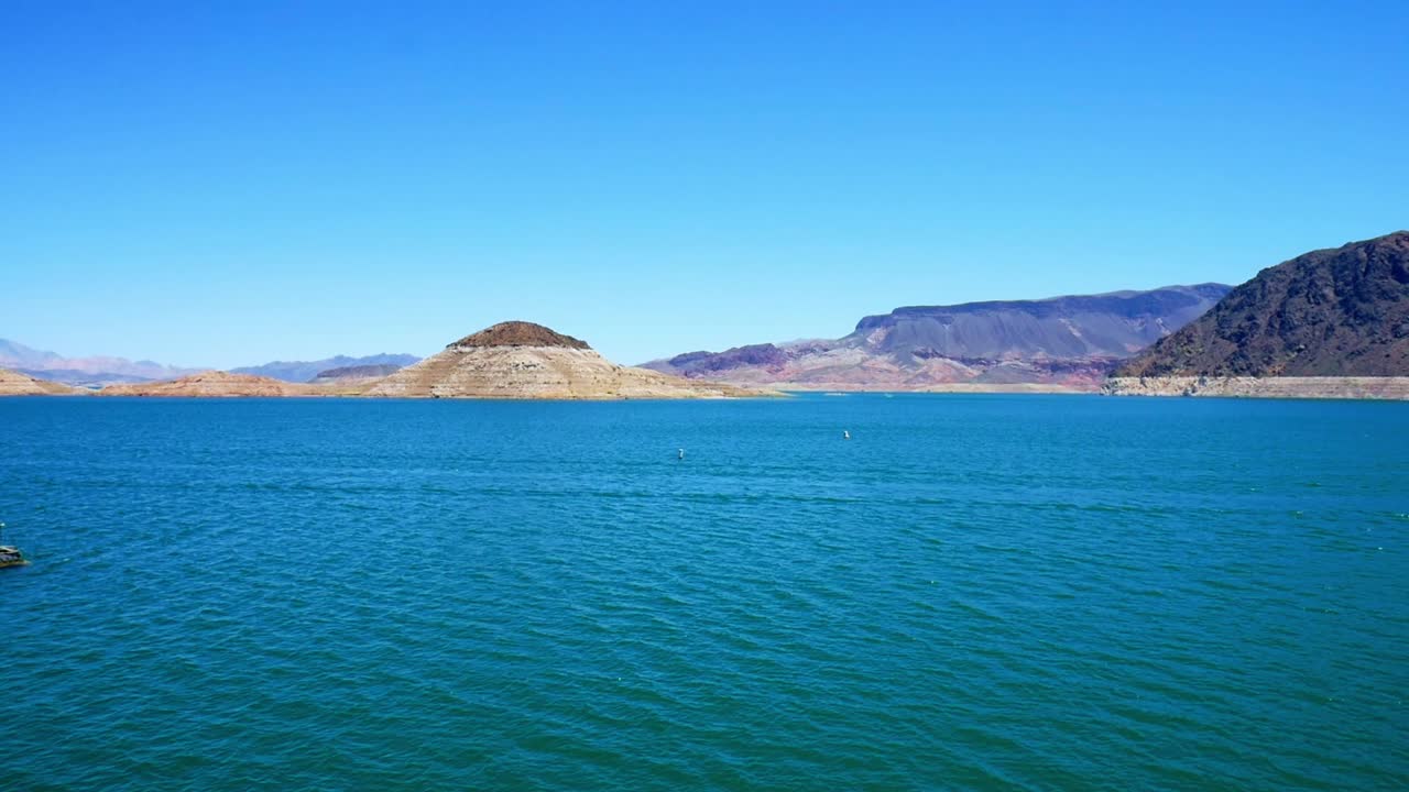 Calm waters on Lake Mead with bathtub ring clearly visable on rocks and mountain sides