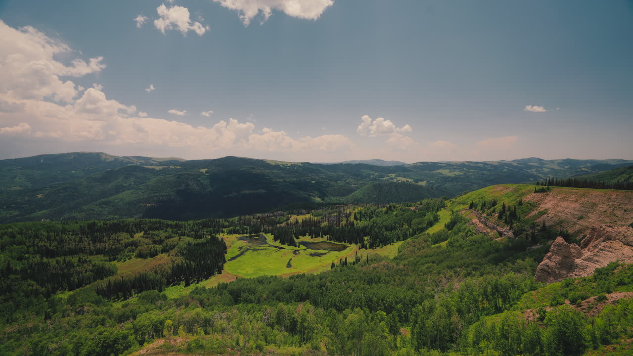 Forested Mountains With Rolling Clouds On A Sunny Day. Timelapse