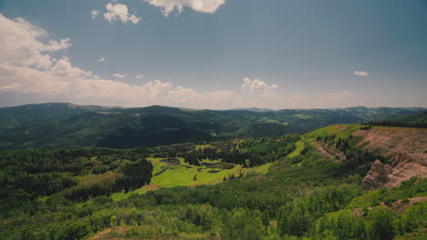 forested mountains with rolling clouds on a sunny day. timelapse