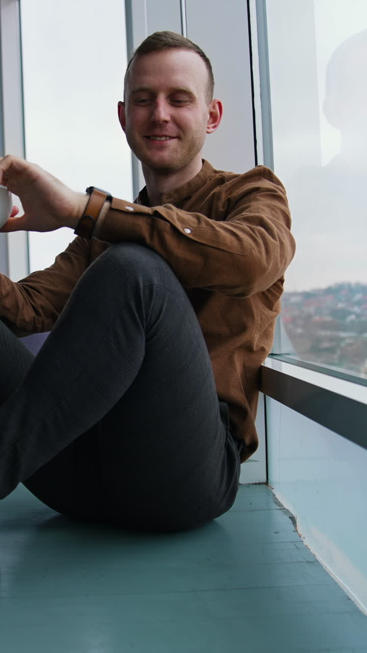 Young businessman drinking coffee Vertical video