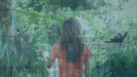 animation of multiple graphs over rear view of biracial woman walking and touching plants