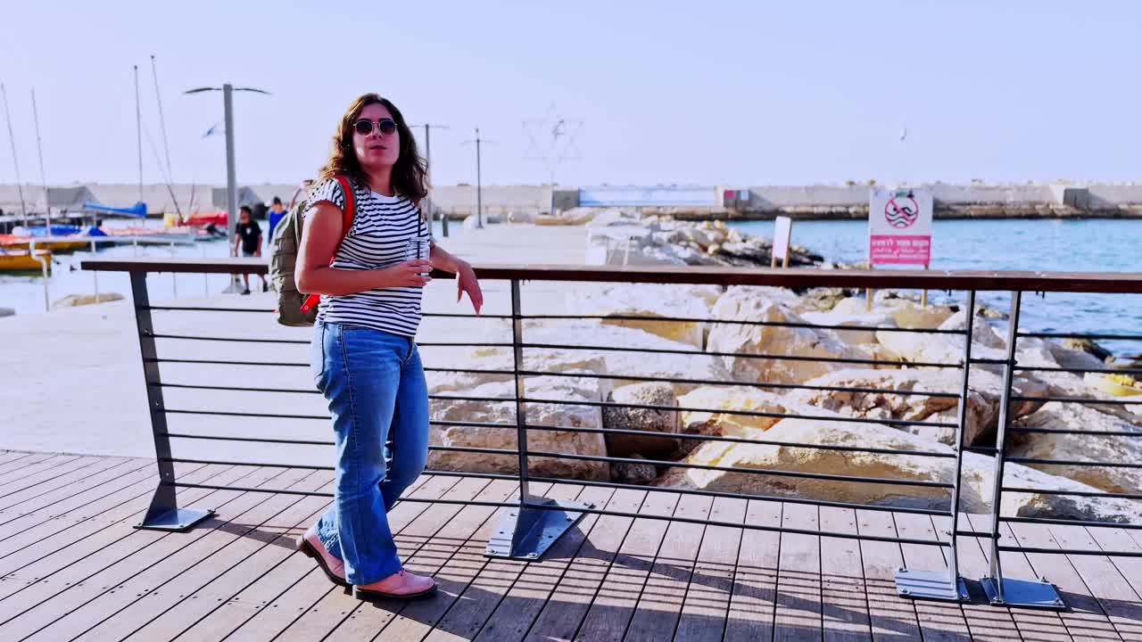 Side View Of Woman Drinking Juice By The Sea Railing