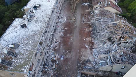 Drone moves forward in dive over debris-filled alley between damaged buildings in Tel Aviv after missile strike