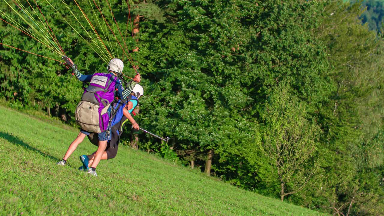 tandem student pilot paragliders launch from hill over the city, Extreme sport