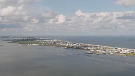 a tracking drone shot of grand isle from the west. includes the waterfront homes, breakwaters, undeveloped land, and caminada bay