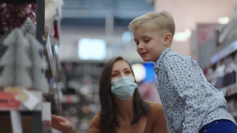 un niño con su madre en la tienda elige un regalo