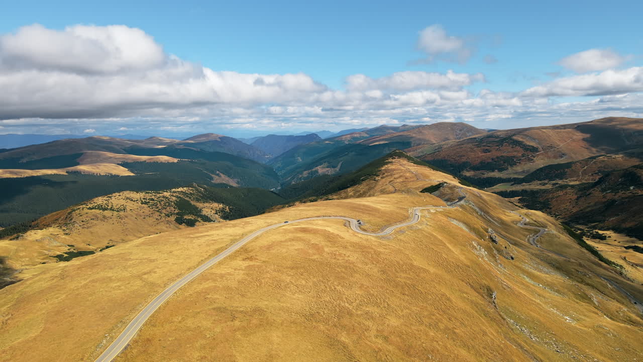 Aerial drone view of nature in Romania. Carpathian mountains, sparse vegetation, Transalpina road with cars