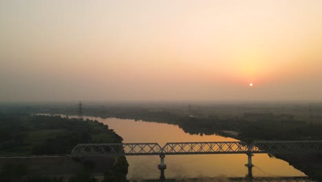 breathtaking sunrise aerial shot of a forest, with mist rising from the river and golden hues in the sky.