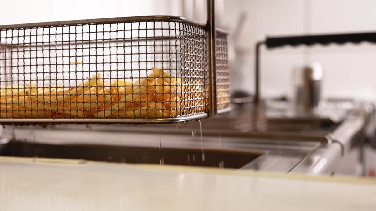 Friturestegning af pommes frites i en professionel frituregryde