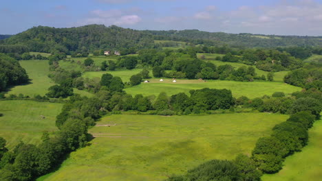 Aerial-flying-towards-Great-Oaks-Glamping-Sunny-day-UK-4K