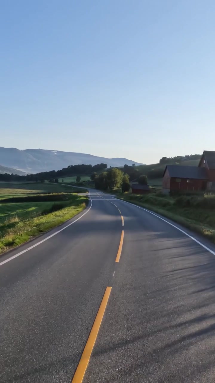Guidare un'auto su una strada in Norvegia all'alba
