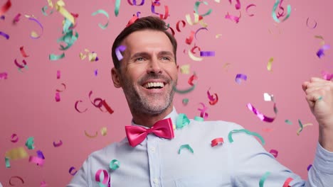 hombre adulto celebrando con confeti, filmado con una cámara de helio rojo en 8k.