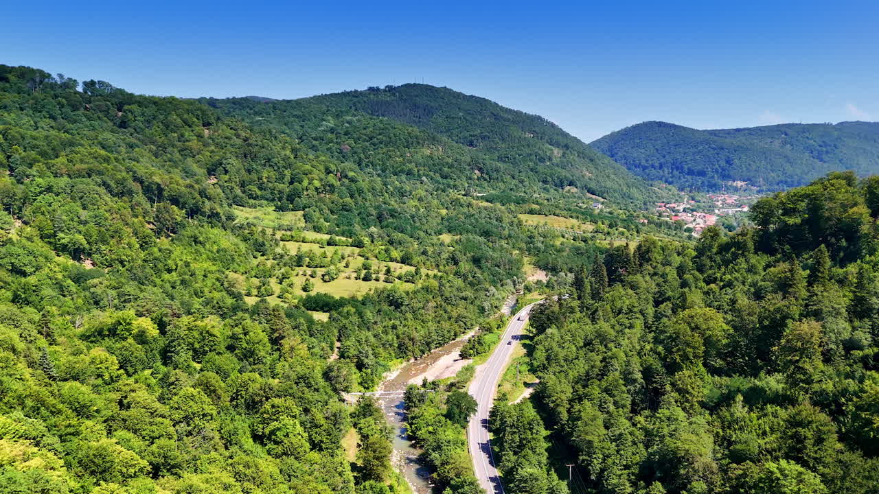 Curvy mountain road view. Lush green hills surround a winding road on a clear sunny day, showcasing the beauty of nature in the mountains