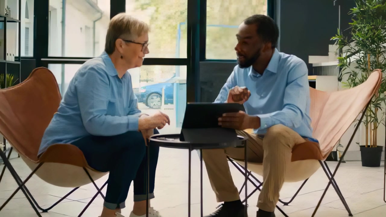 Pointing woman initiating discussion, man and woman wearing shirts leaning toward tablet, cane